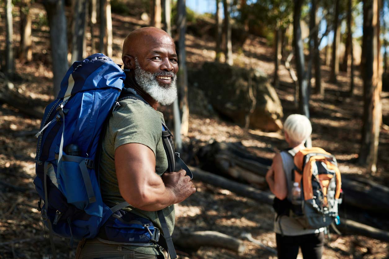 Elderly man and woman hiking on a trail - exercise can balance hormones naturally