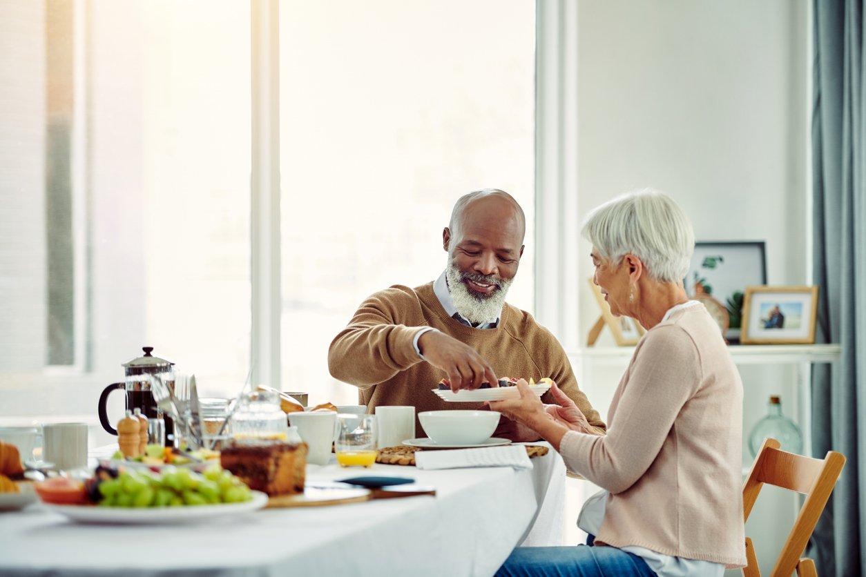 Shot of a cheerful senior couple talking and enjoying breakfast together at home