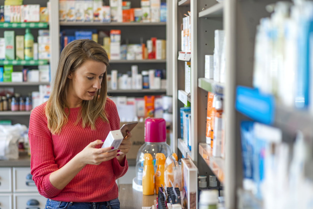 Mid adult female customer choosing product at pharmacy