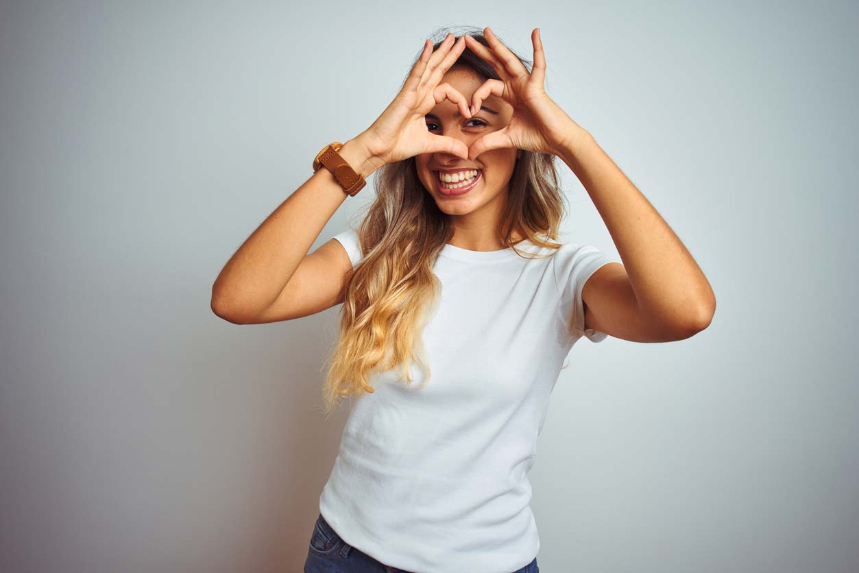 Woman making heart with fingers in front of eyes