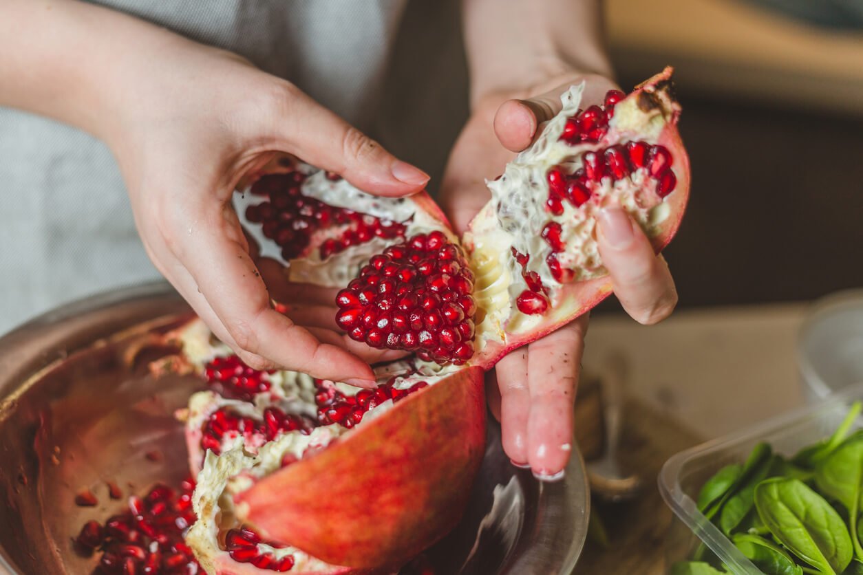 young hands of the girl cut and cleaned fresh juice pomegranate