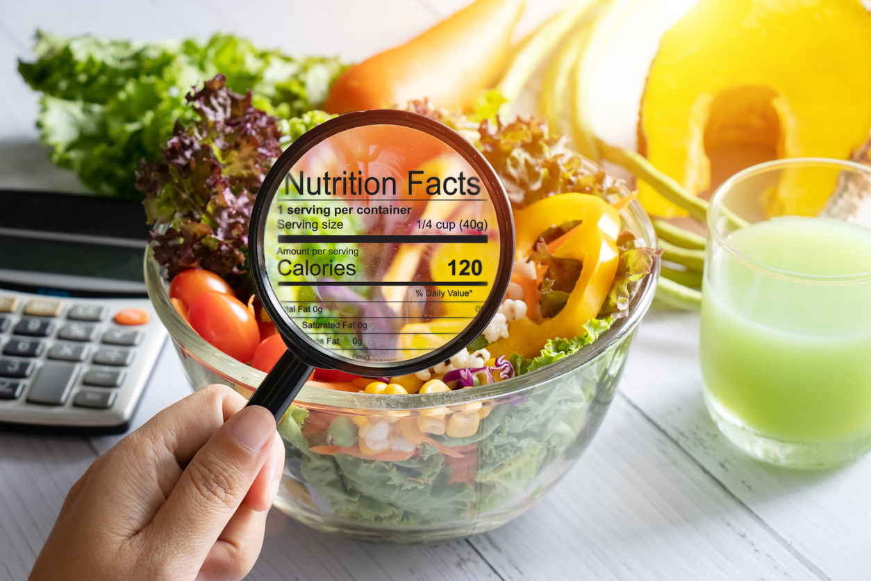 Nutrition Facts with Calories under a magnifying glass over a salad