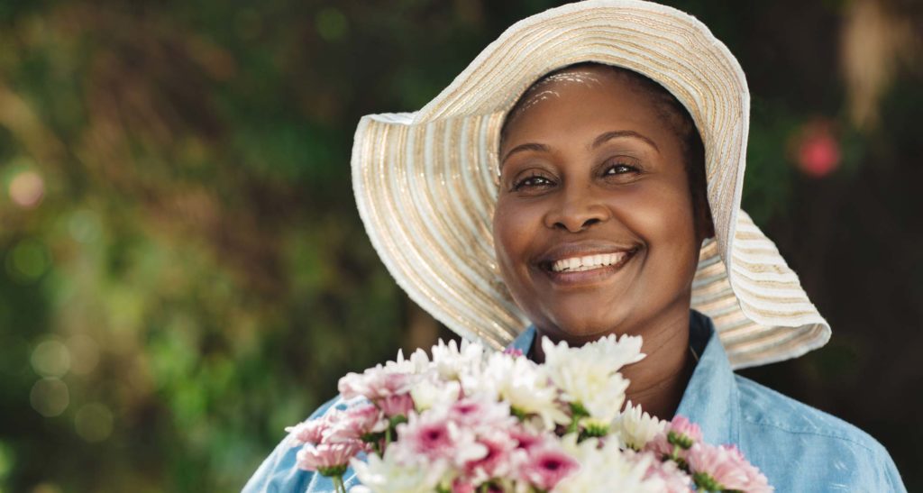 Black woman with sunhat and flower bouquet