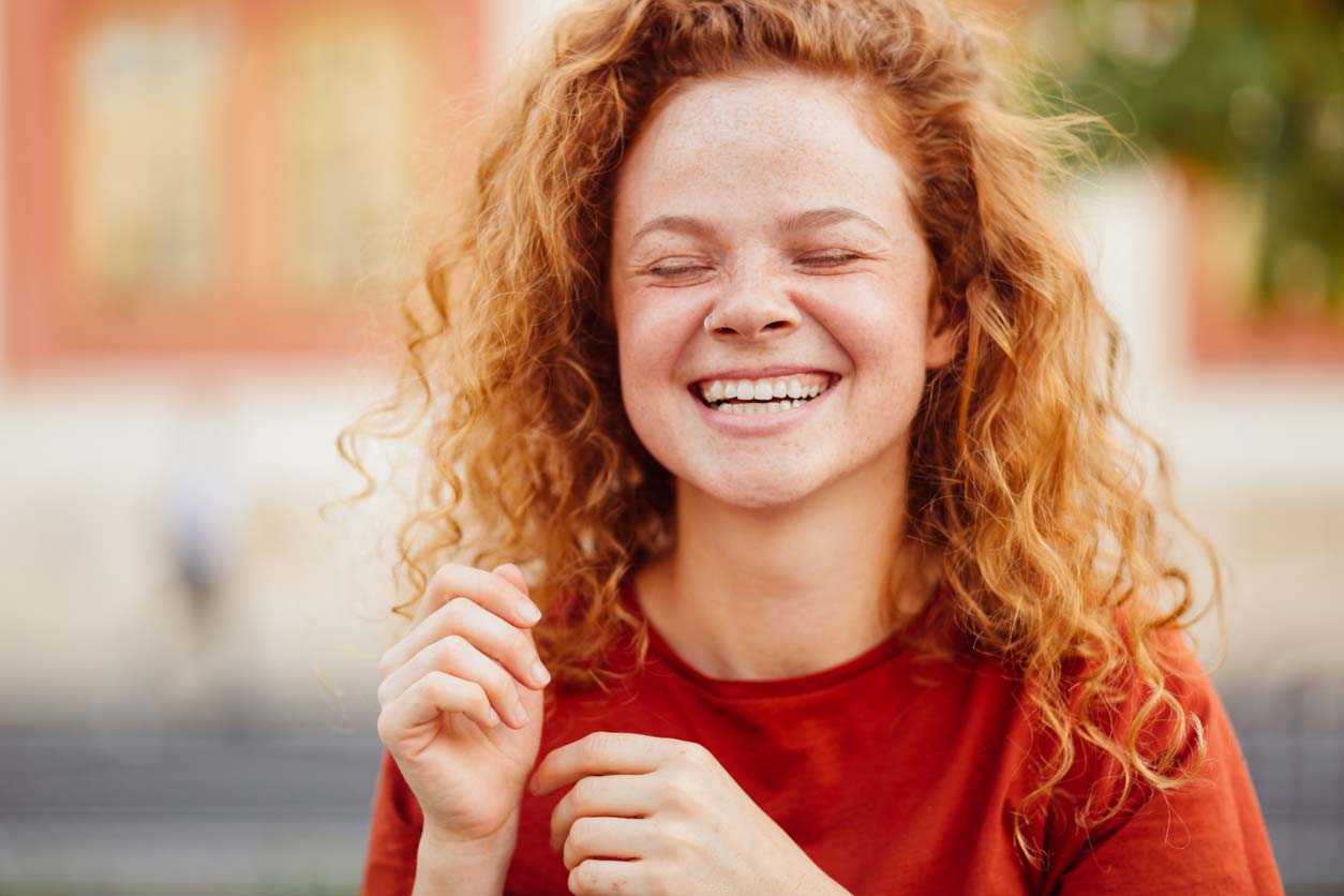 portrait of woman outdoors smiling with healthy hair