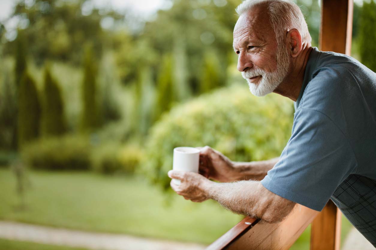 elderly man enjoying nature with cup of coffee