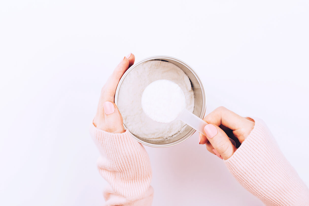 a jar with collagen powder and scoop spoon in woman hands