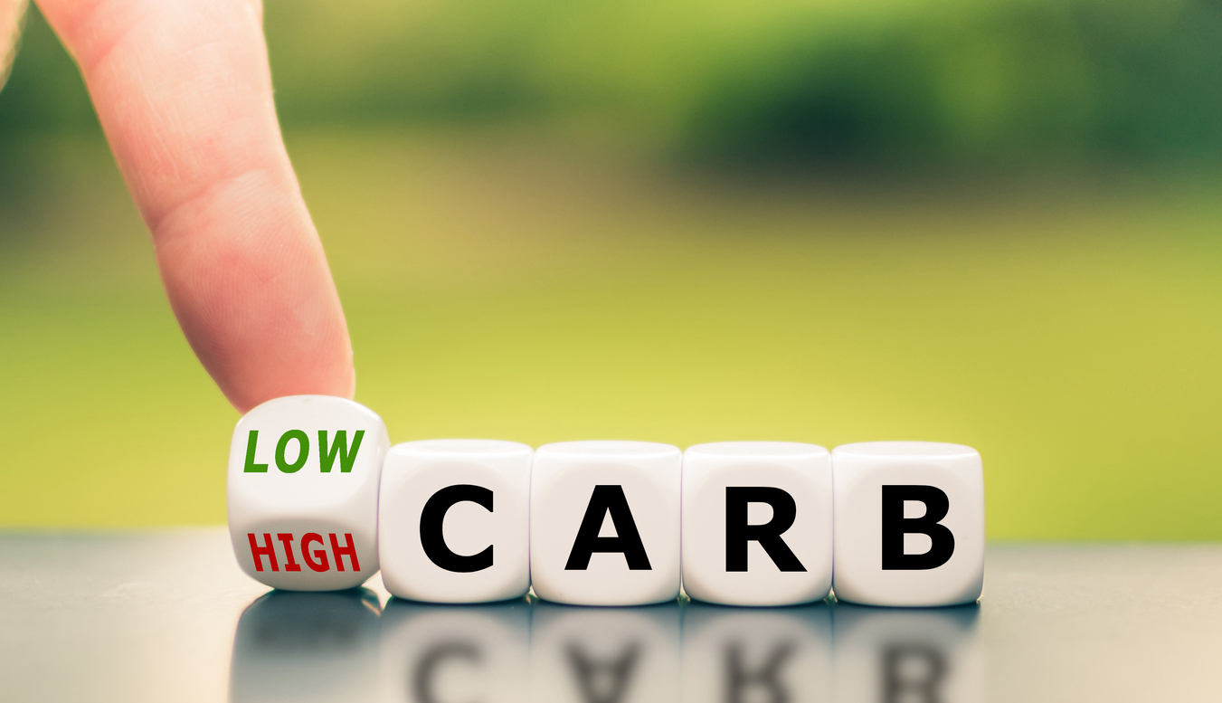 Hand turns a dice and changes the expression from "high carb" to "low carb".