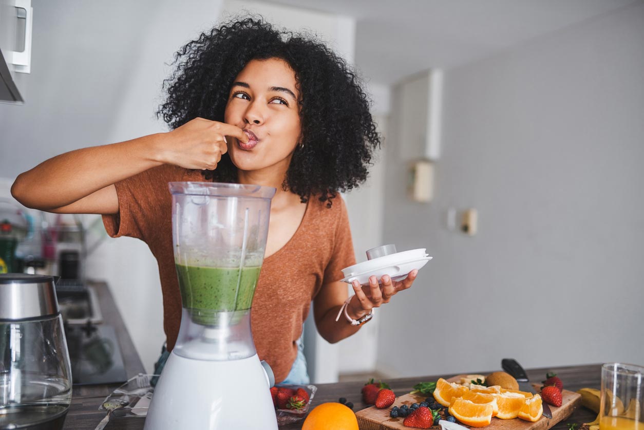Woman enjoying a green smoothie. Adequate nutrition affects your mental health.