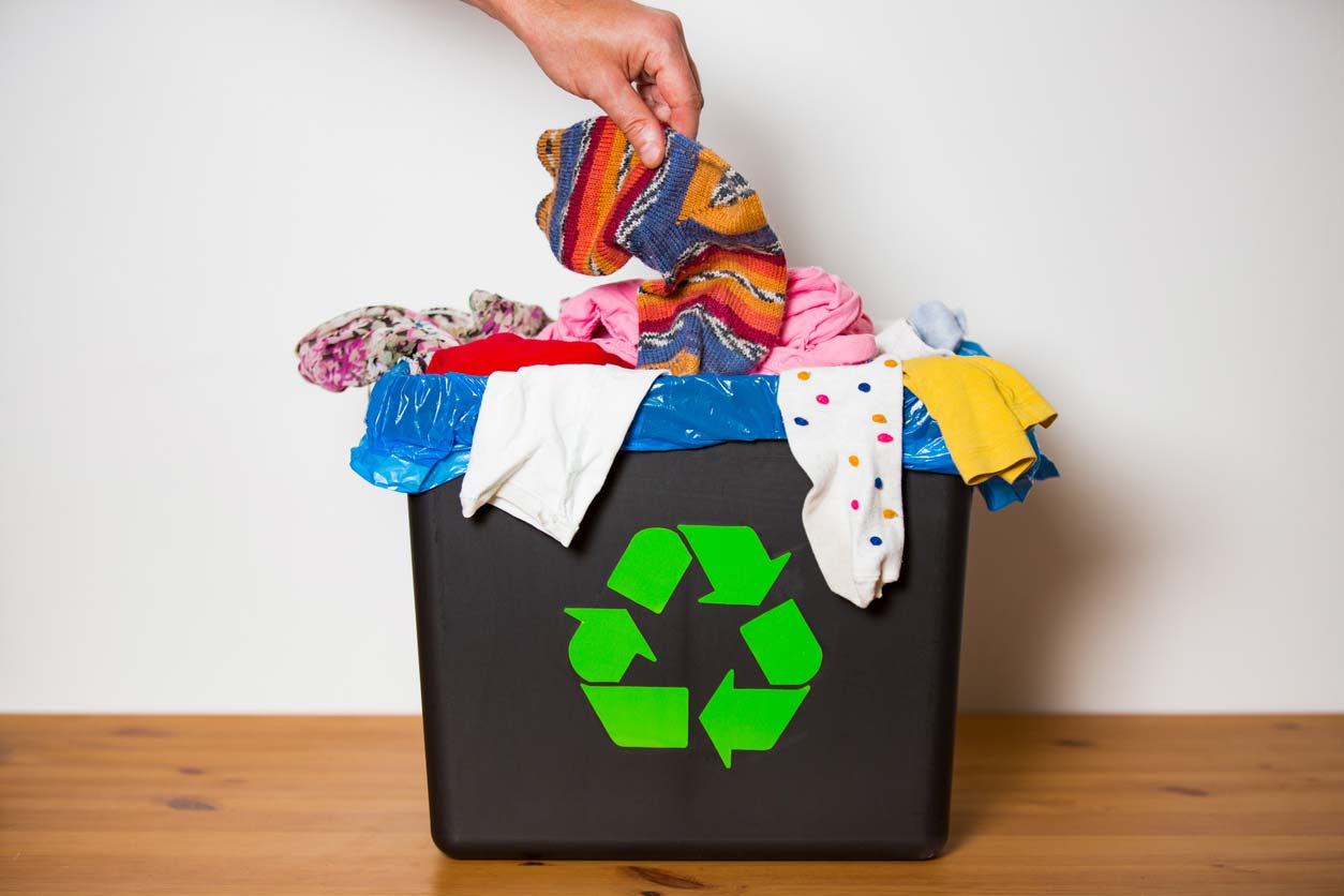 hand putting used sock in recycling bin