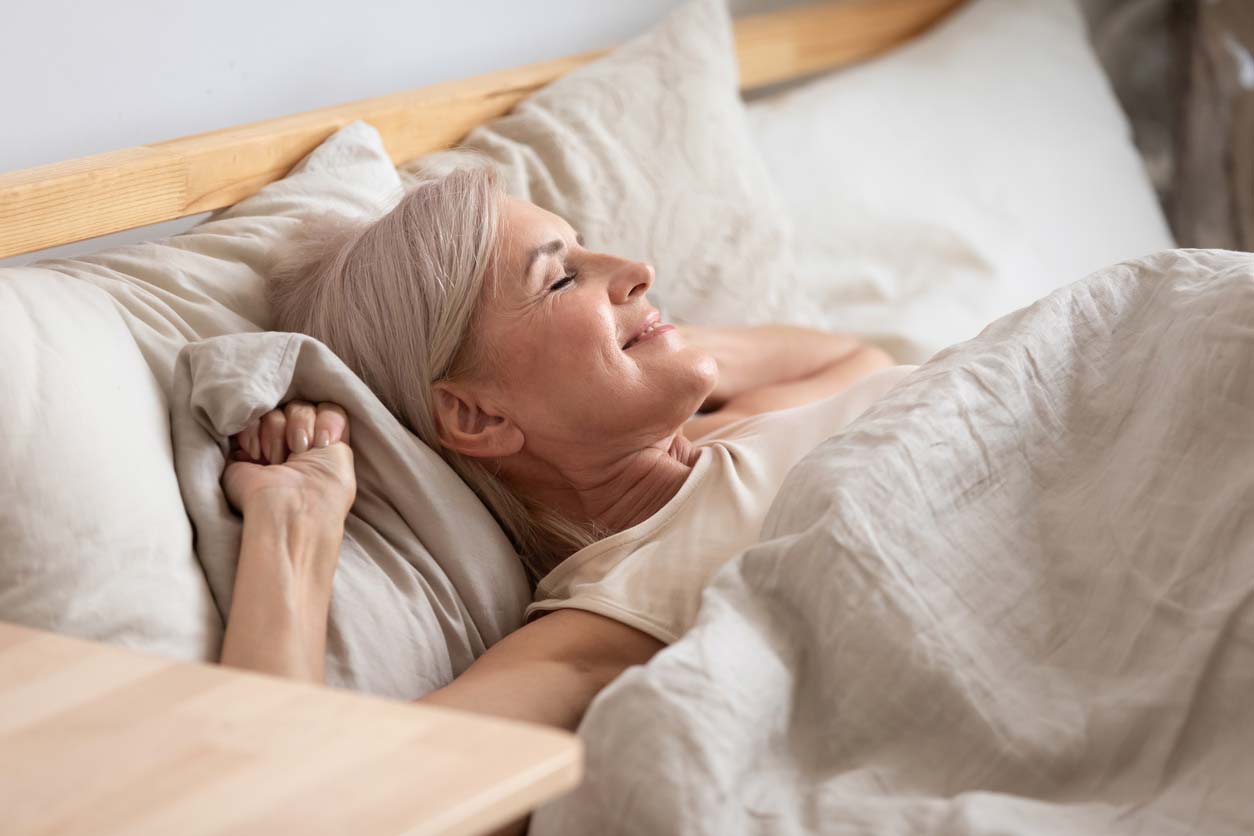 Senior woman stretching in bed