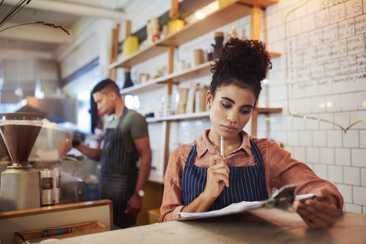 woman looking over inventory checklist in coffee shop