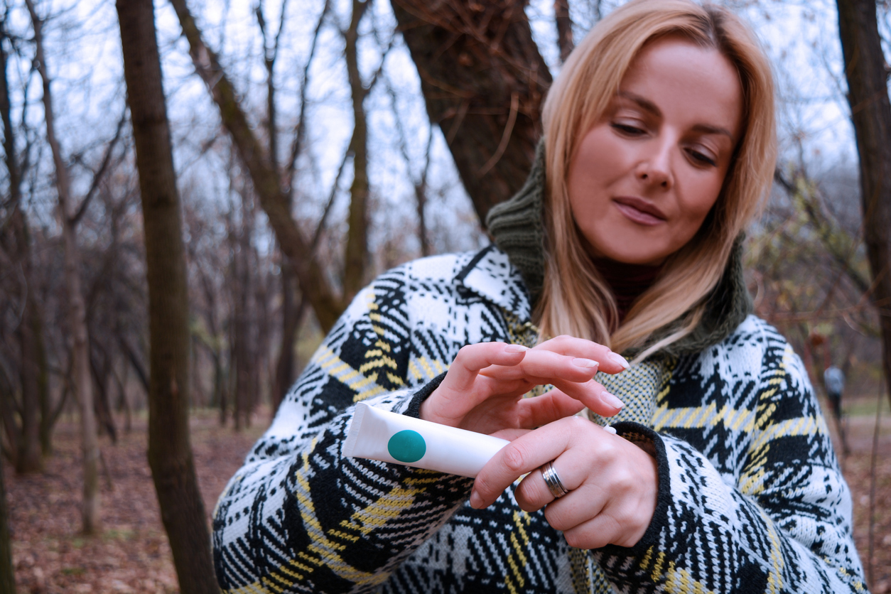 Woman use hand cream on dry hand. Skin Care Concept Close up of a woman hand hydrating skin applying cream in winter.