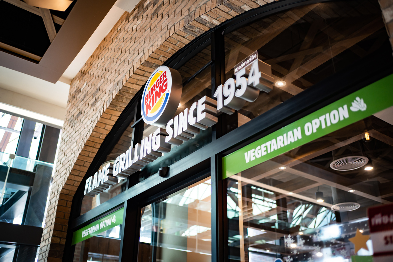 The label in front of the Burger King, hamburger fast food restaurant, showing that they have vegetarian option.