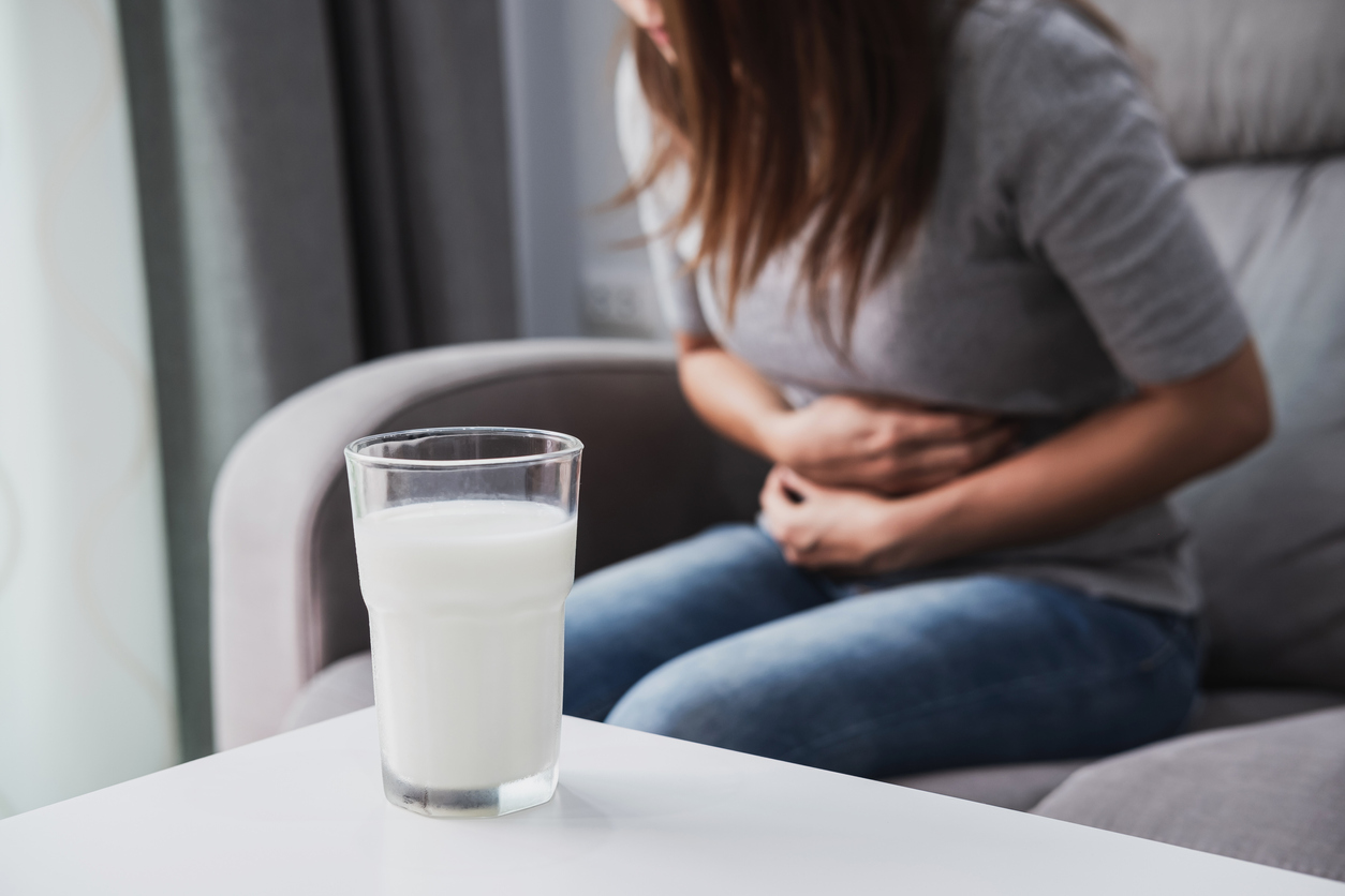 Woman having bad stomach ache with a glass of milk, Lactose intolerance, health care concept