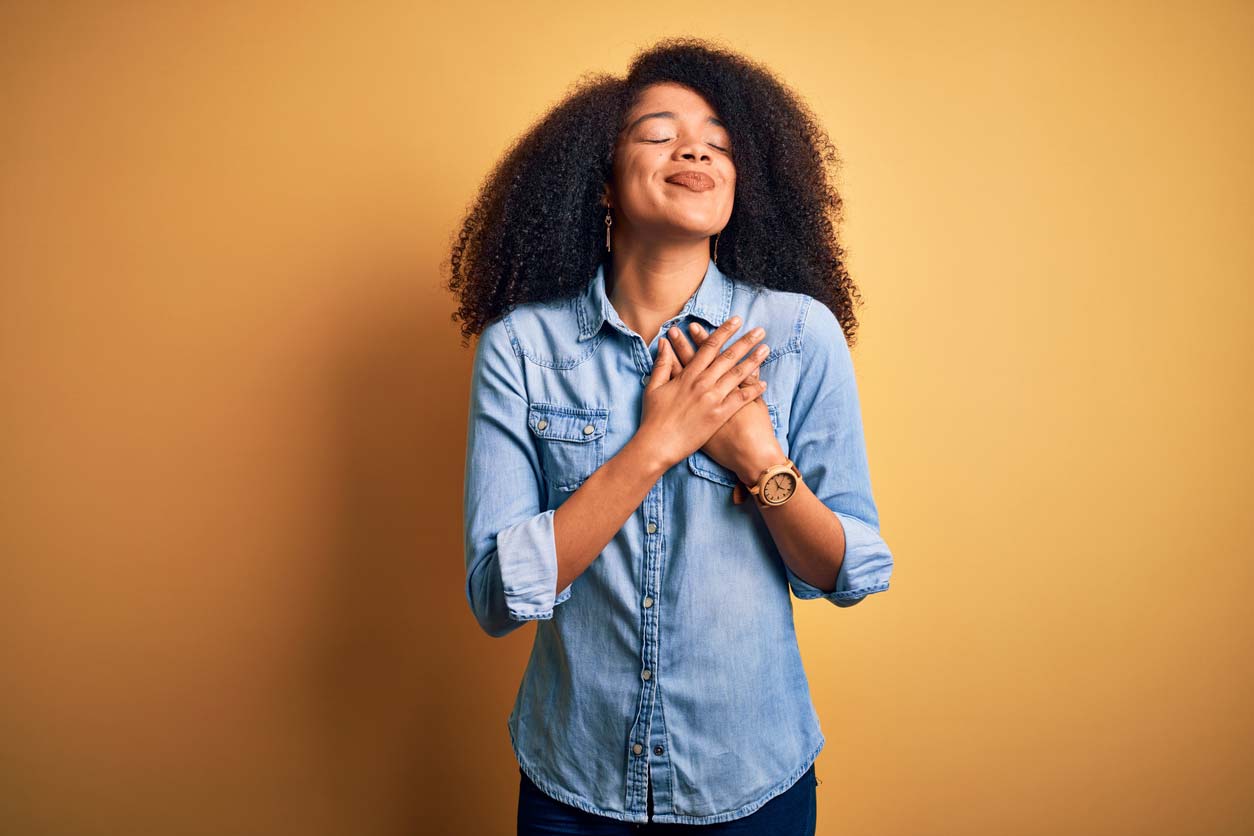 grateful woman holding hands crossed over heart