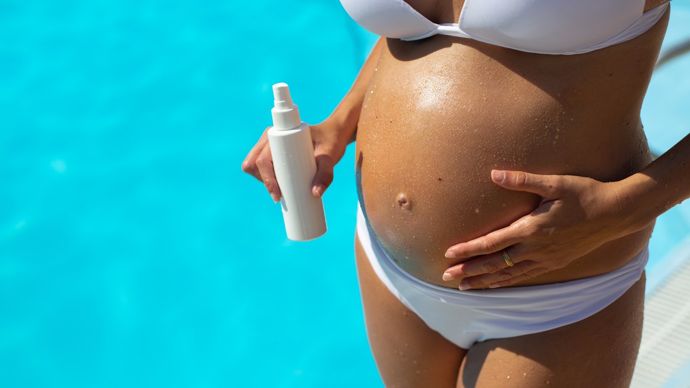 Pregnant woman on summer at swimming pool