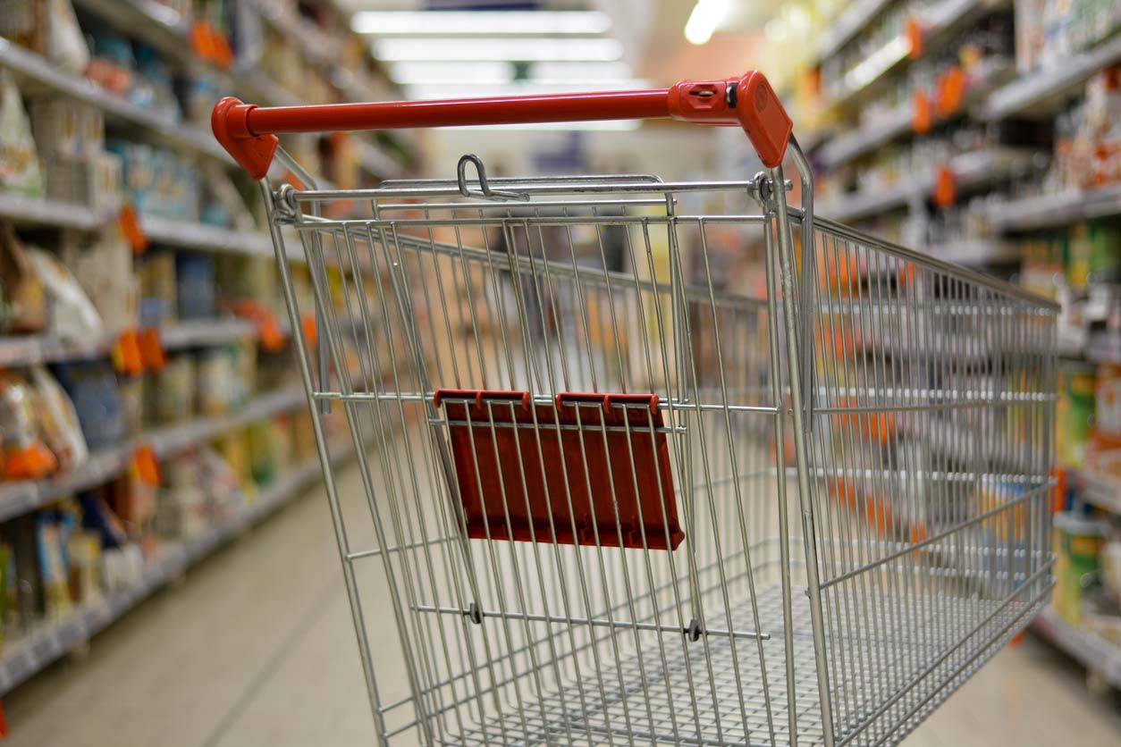 empty grocery cart in grocery aisle