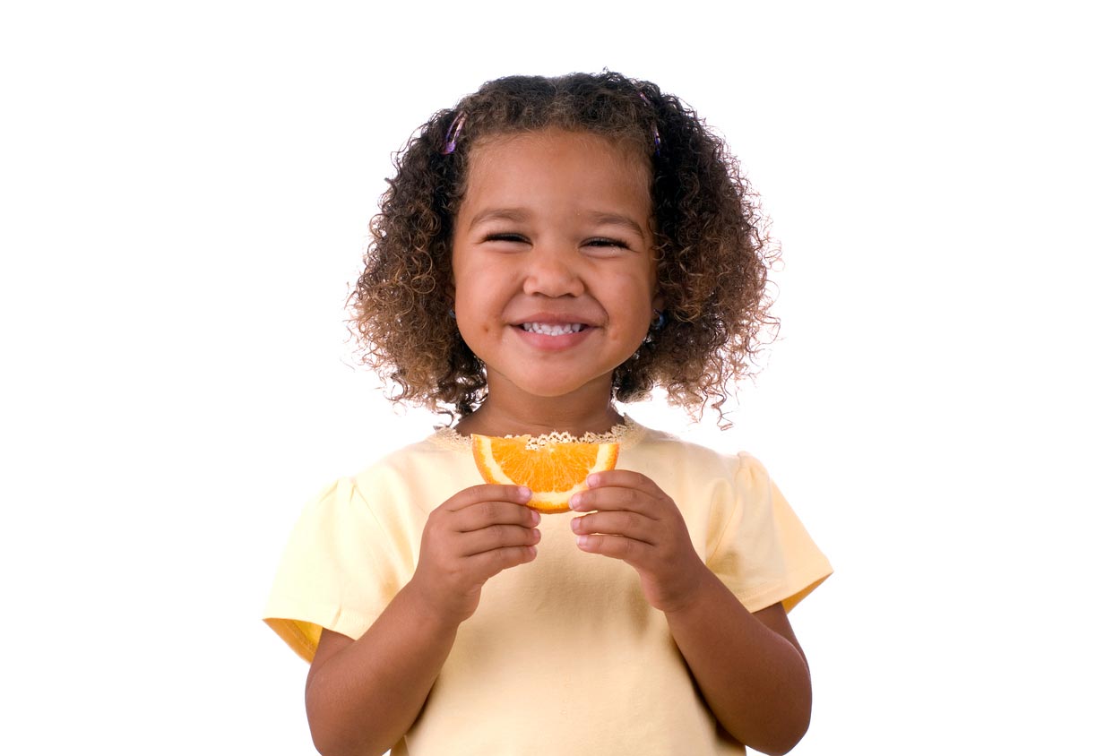 little girl holding an orange slice