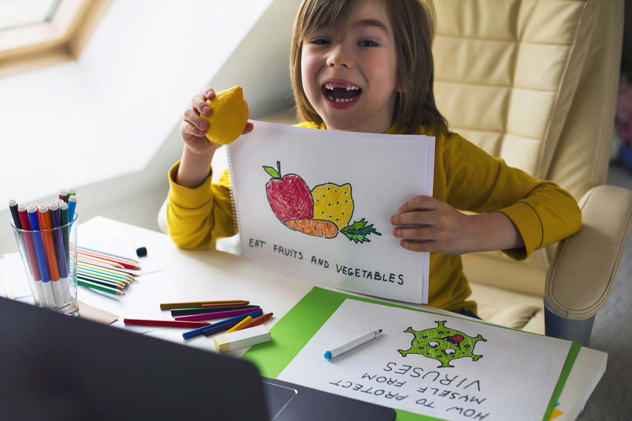 child with drawing of what helps with covid and other viruses: "eat fruits and vegetables."