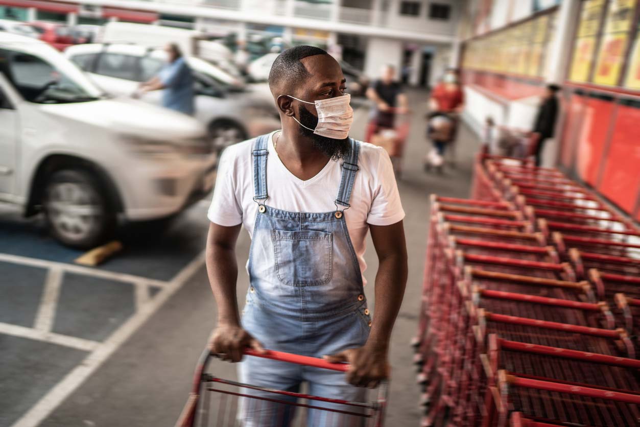 Black man with face mask grabbing grocery cart