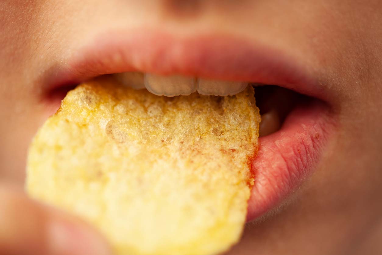closeup of person eating crunchy potato chip
