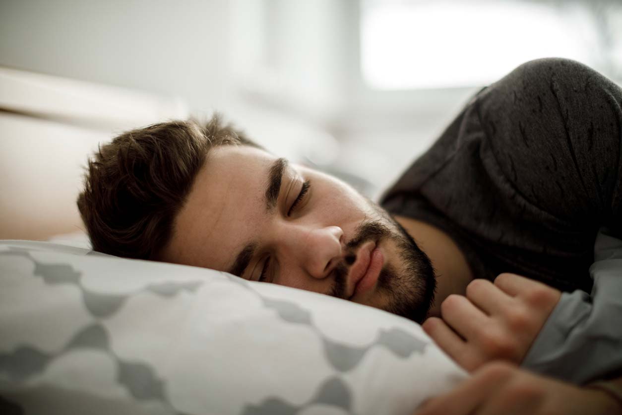 Man in bed sleeping on pillow