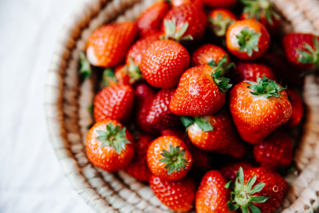 Top view of fresh strawberries in a woven basket