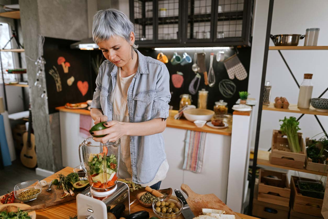 woman preparing smoothie in blender