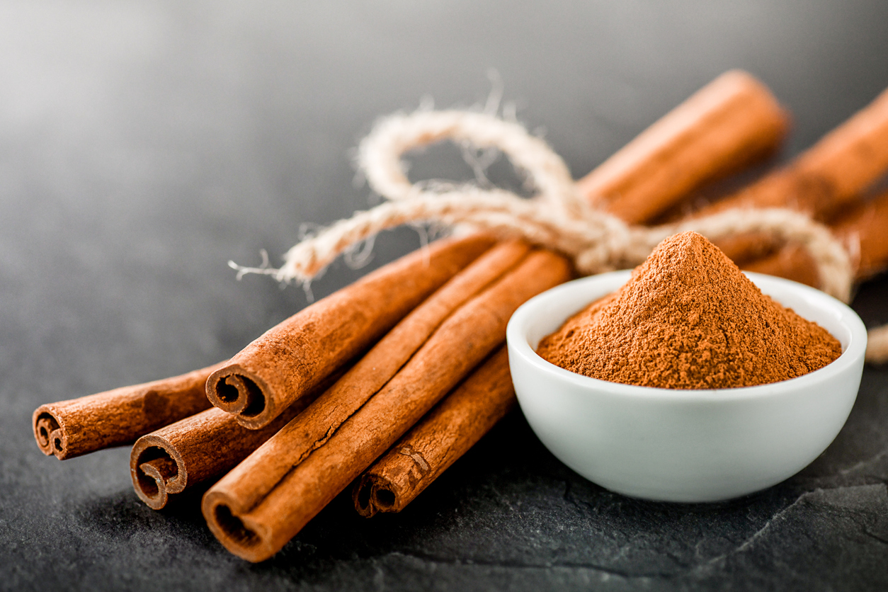 Cinnamon sticks spices on dark stone table.