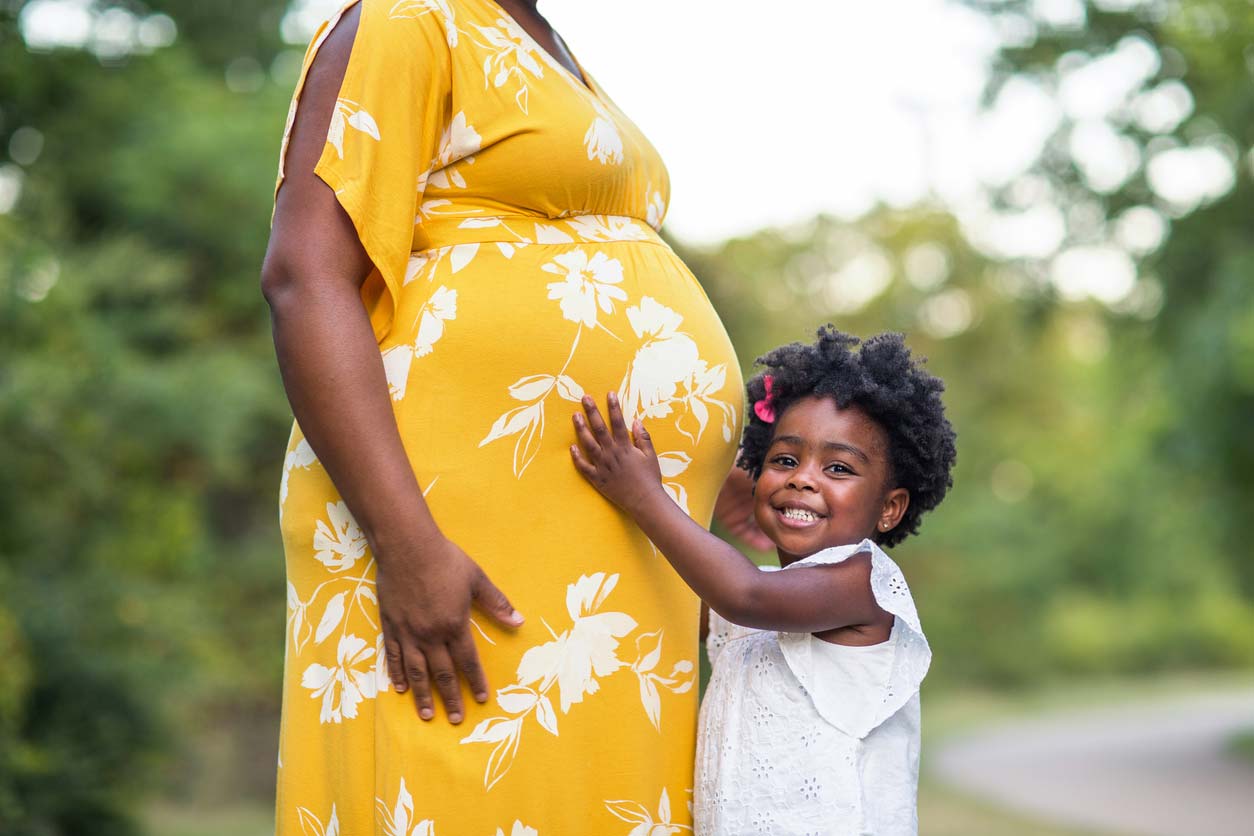 child hugging pregnant mother's belly