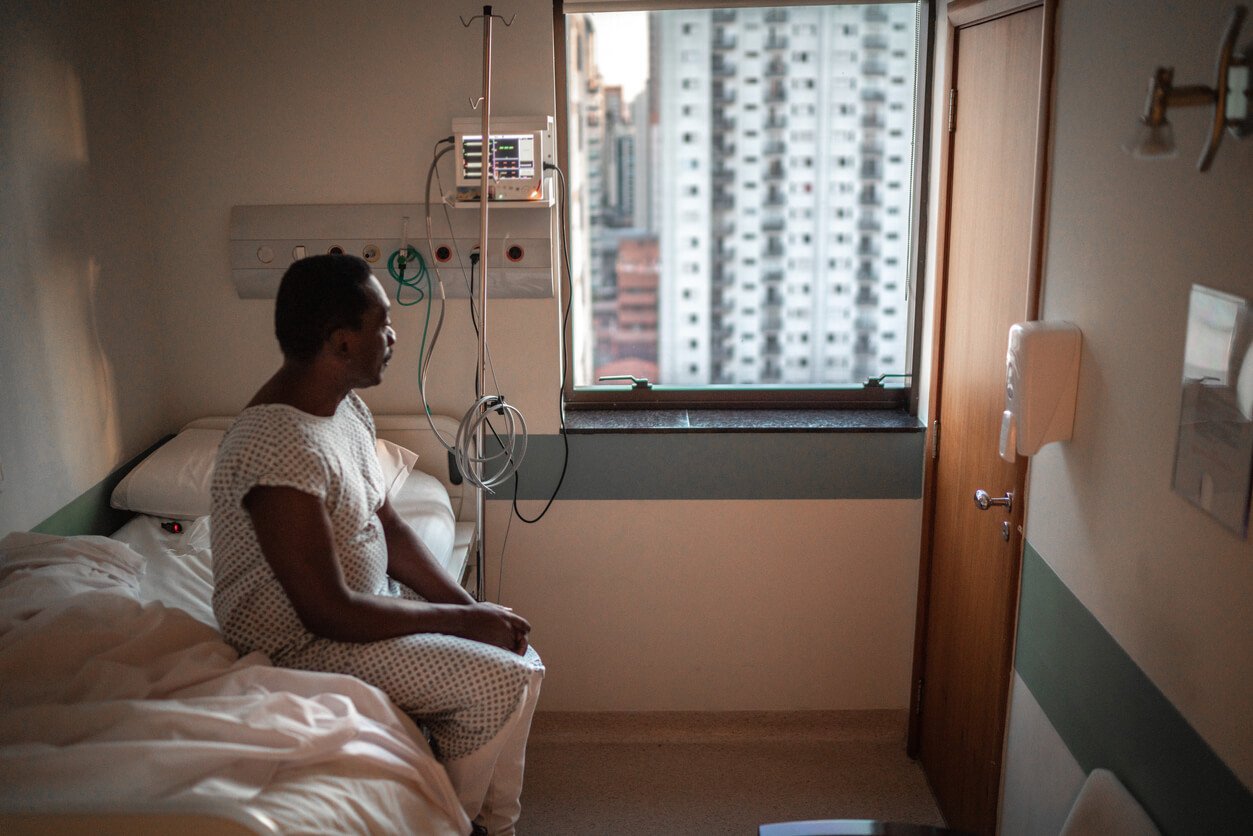 senior patient looking through window at hospital