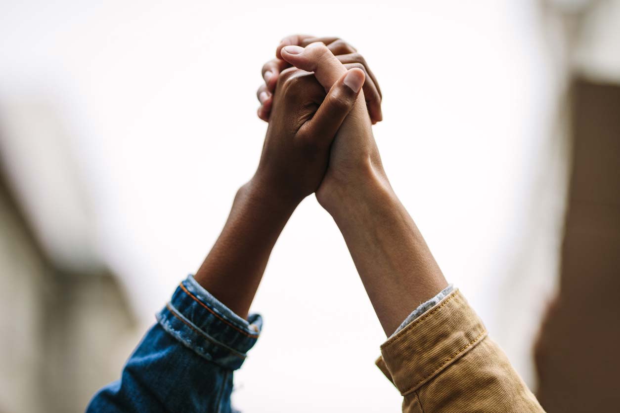 Working together against health inequality with hands raised together