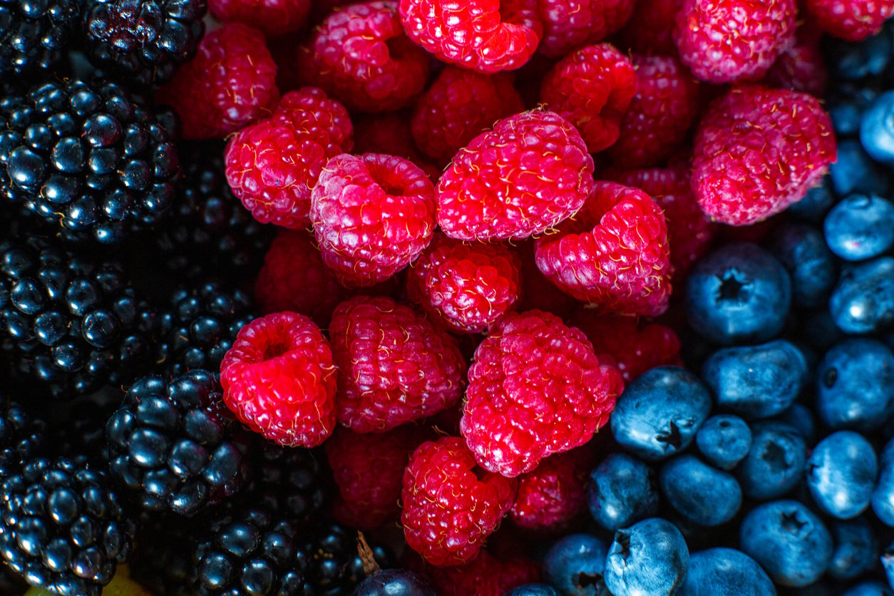 Mix of summer berries vitamins. Mulberry, raspberry and blueberry. Stylish layout on a black table.