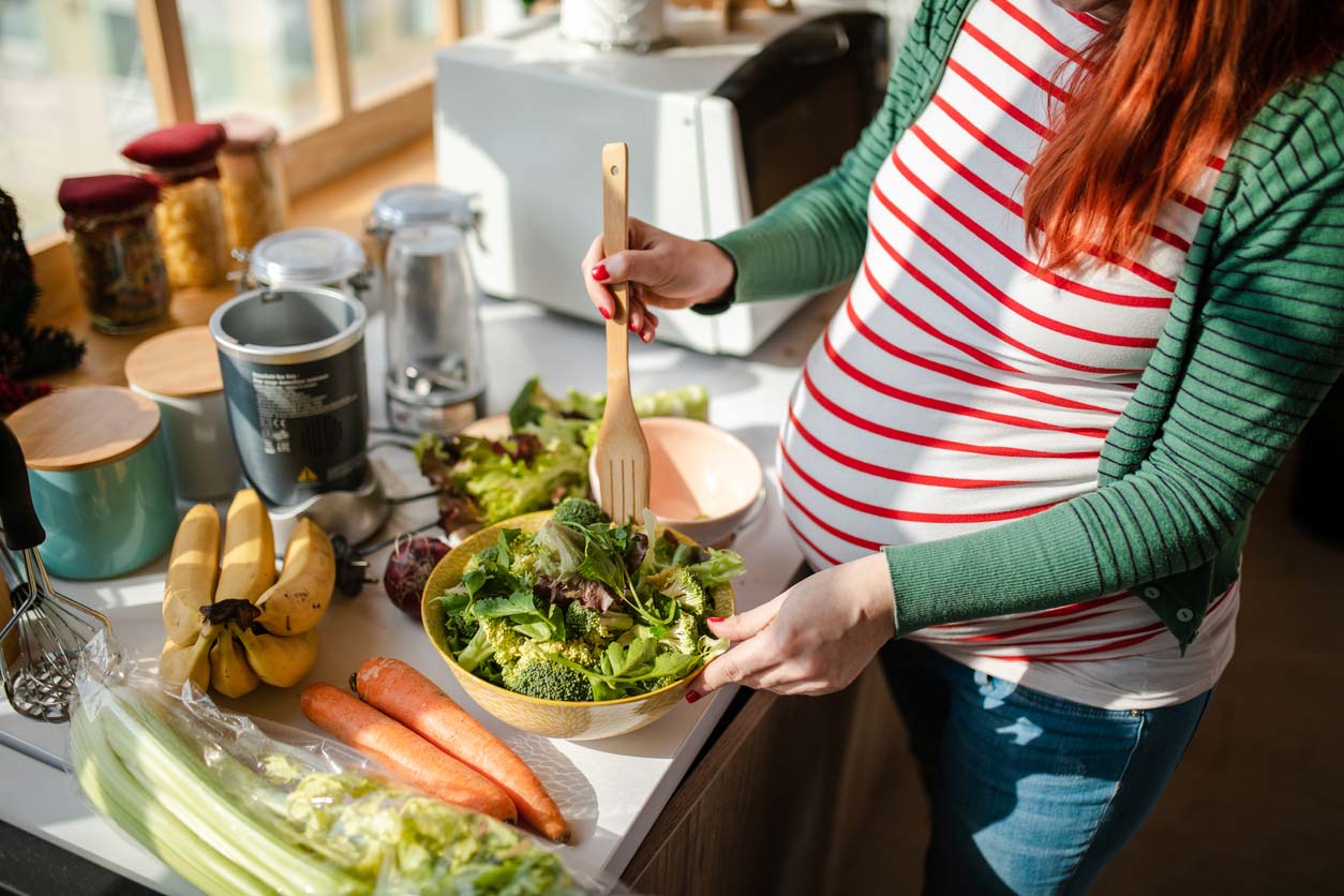 pregnant woman preparing salad