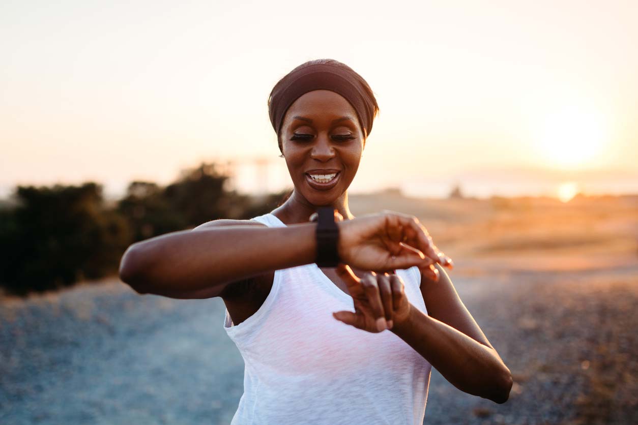 adult woman checking distance on fitness tracker while running