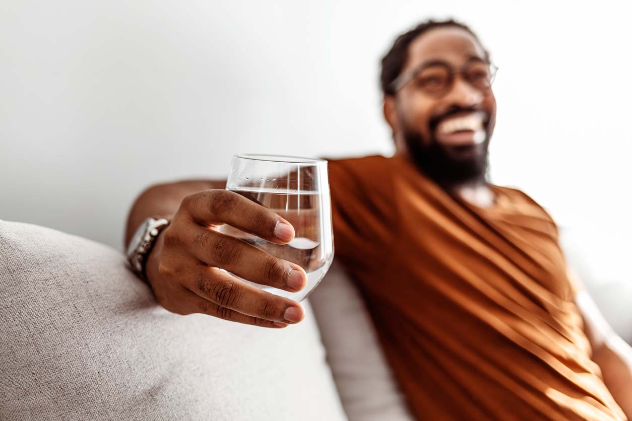 smiling man holding glass of water