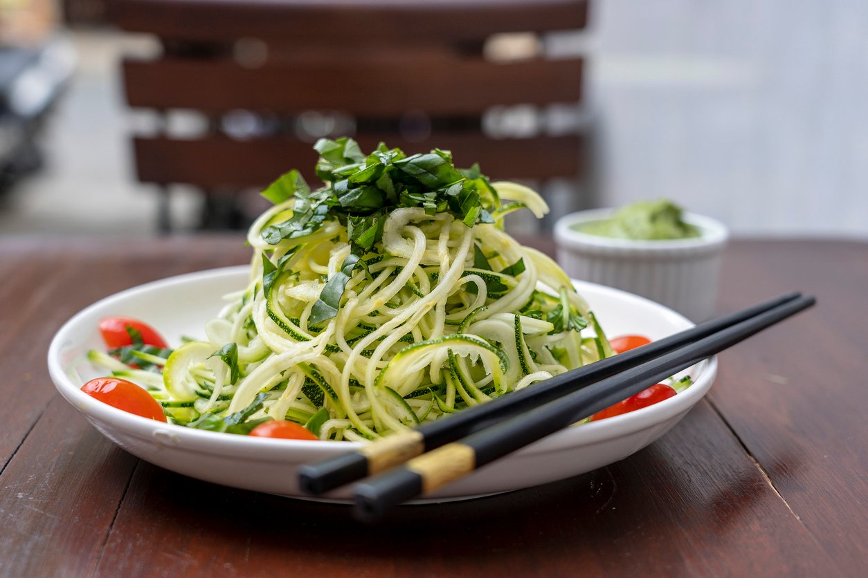 Spiralizer recipe with spiralized zucchini, cucumber, cherry tomato, garlic in a creamy pesto from avocado.