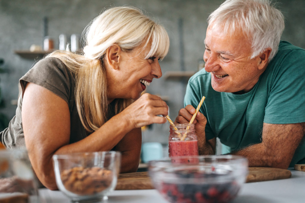 Loving senior couple drinking healthy dessert smoothie together