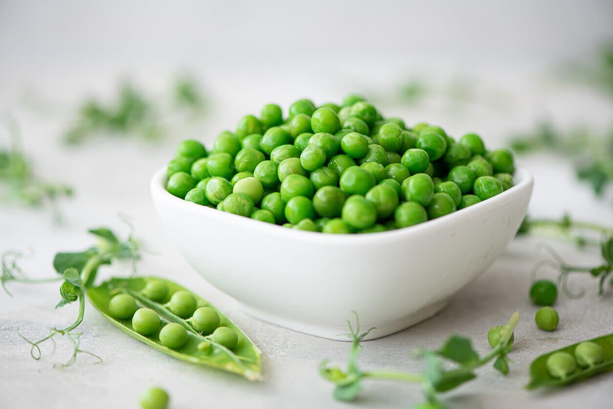 a white bowl of green peas