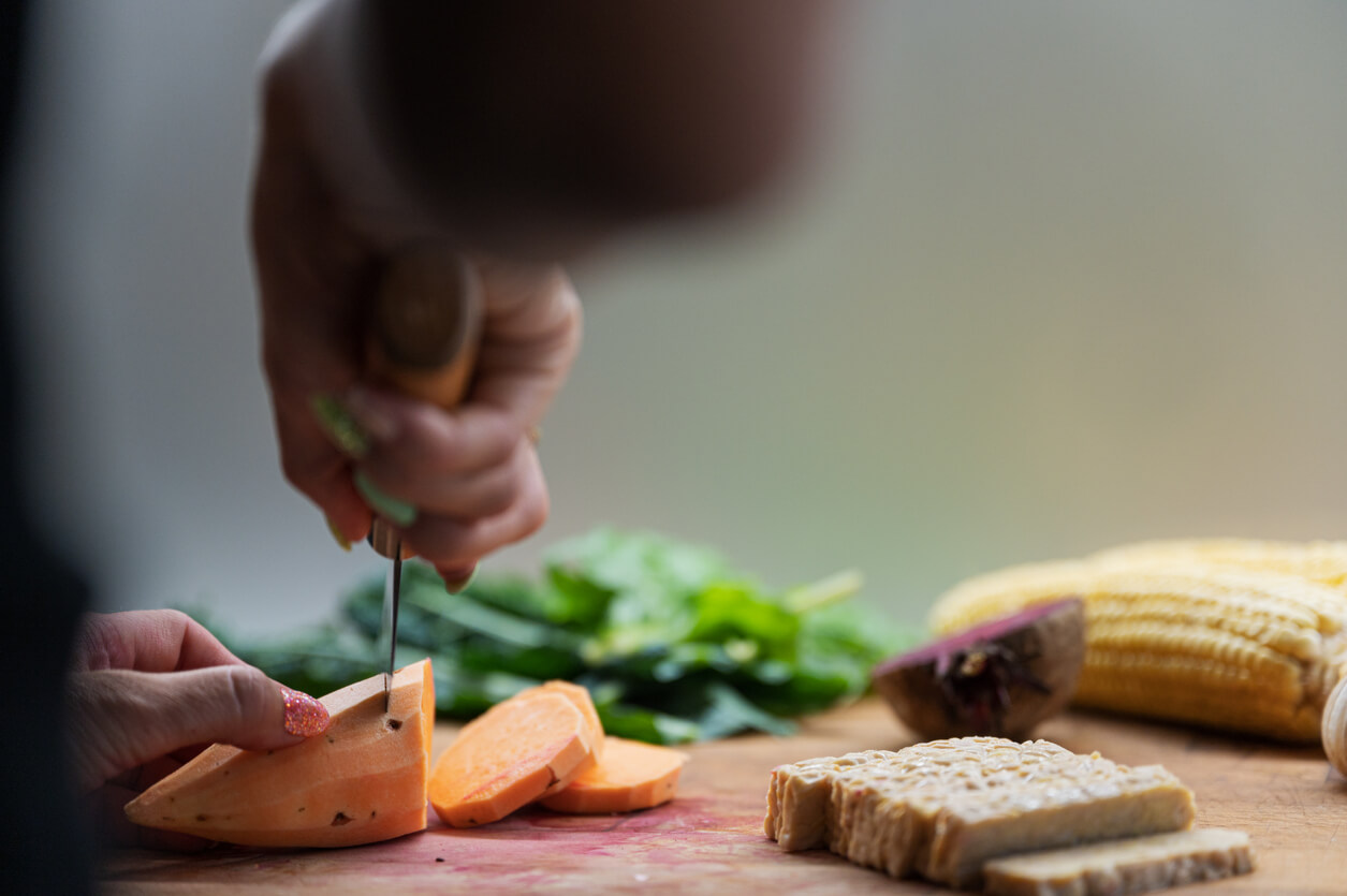 low angle view of a woman cutting tempeh on a cutting board