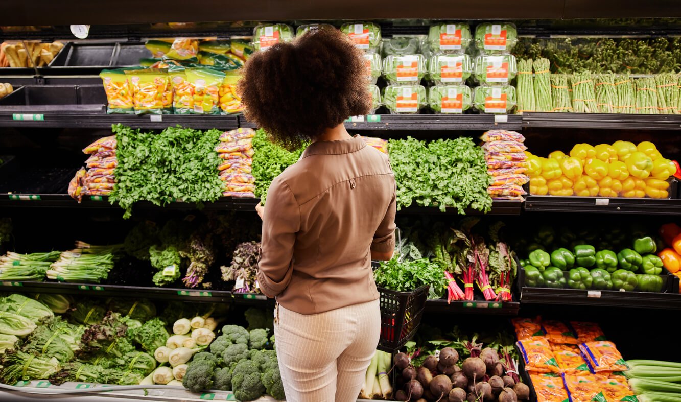 young woman looking at the produce section in a supermarket