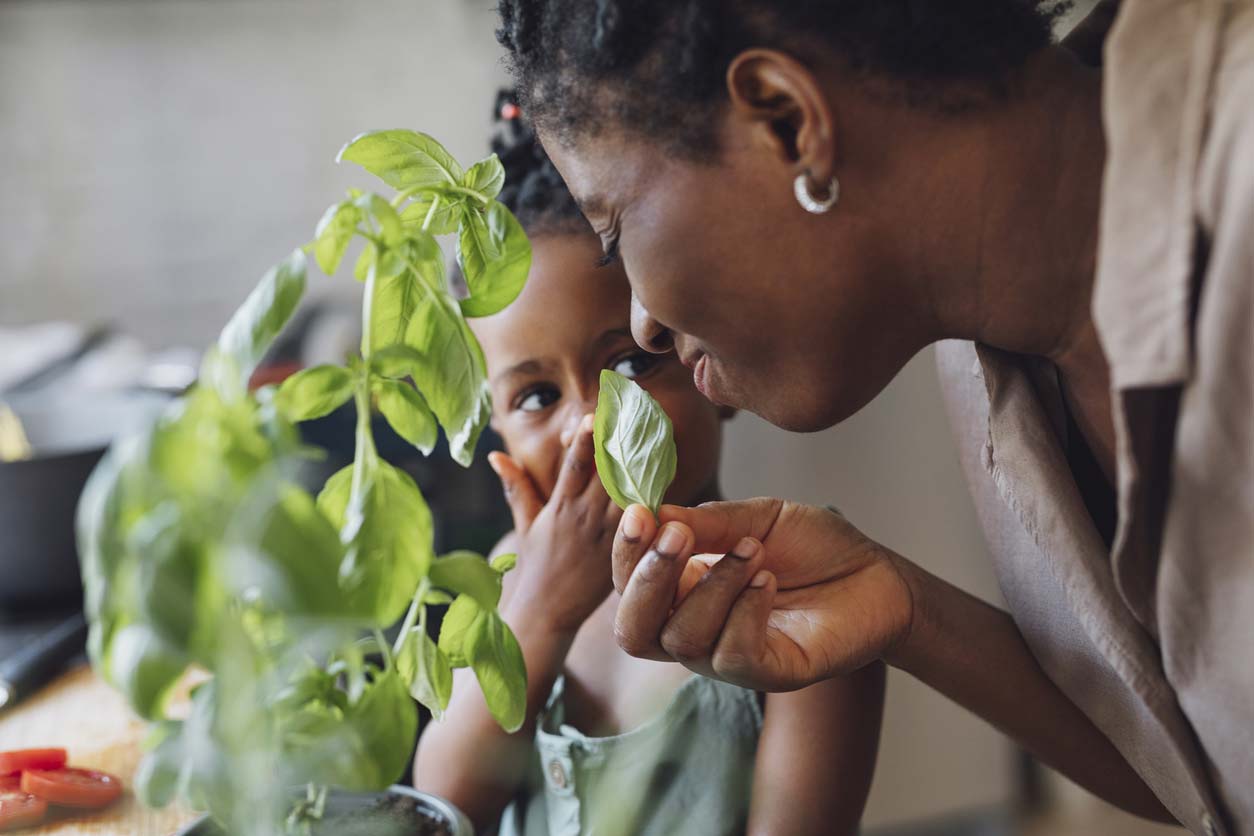 mother and daughter smelling basil