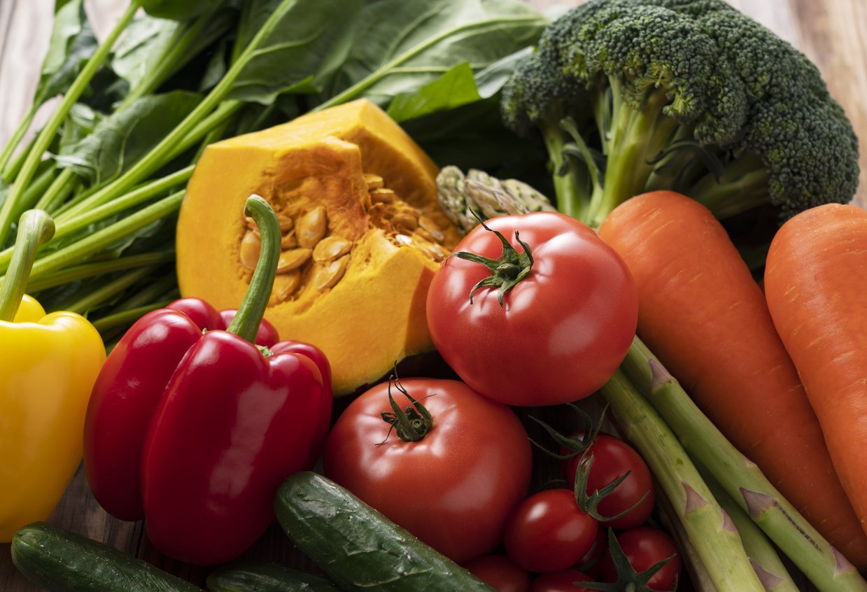 Many kinds of fresh vegetables placed on a wooden background