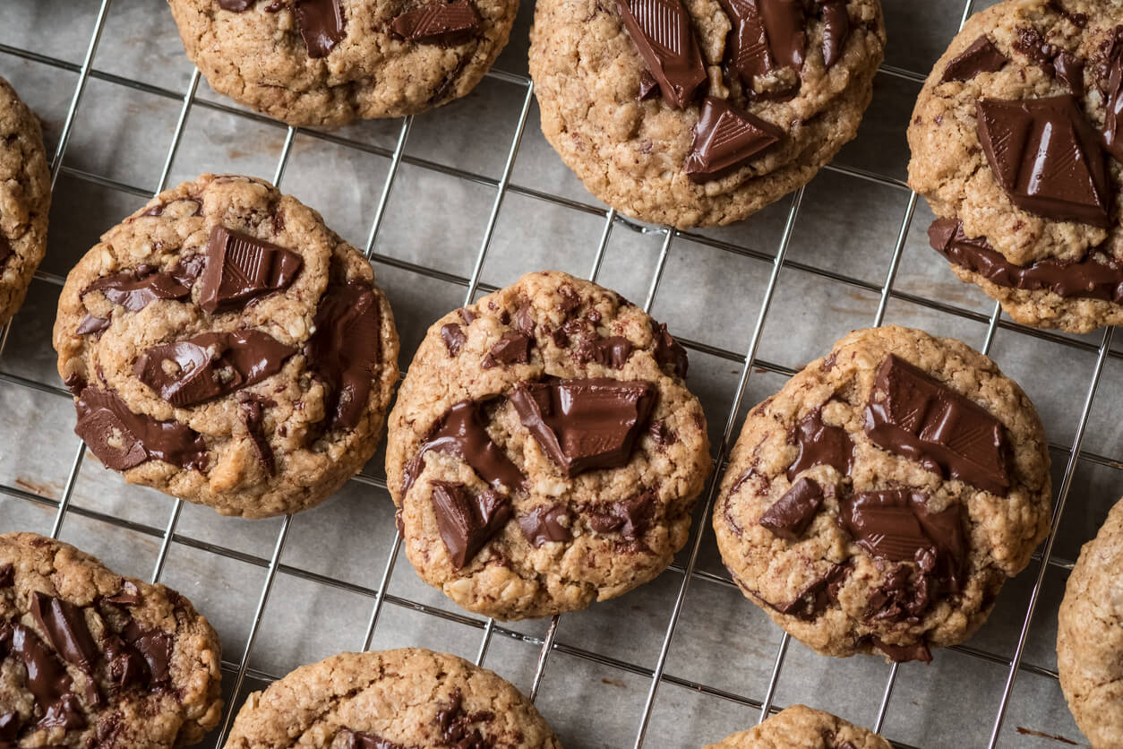 vegan homemade chocolate chunk cookie warm desserts on cooling rack flat lay 