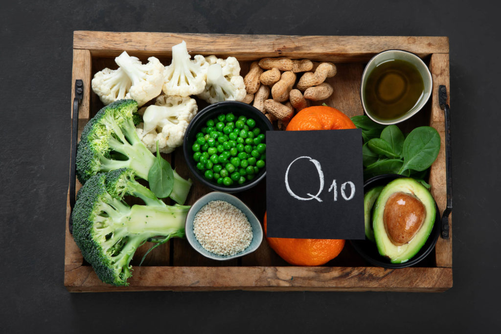 Foods containing CoQ10 in a wooden tray with a Q10 sign