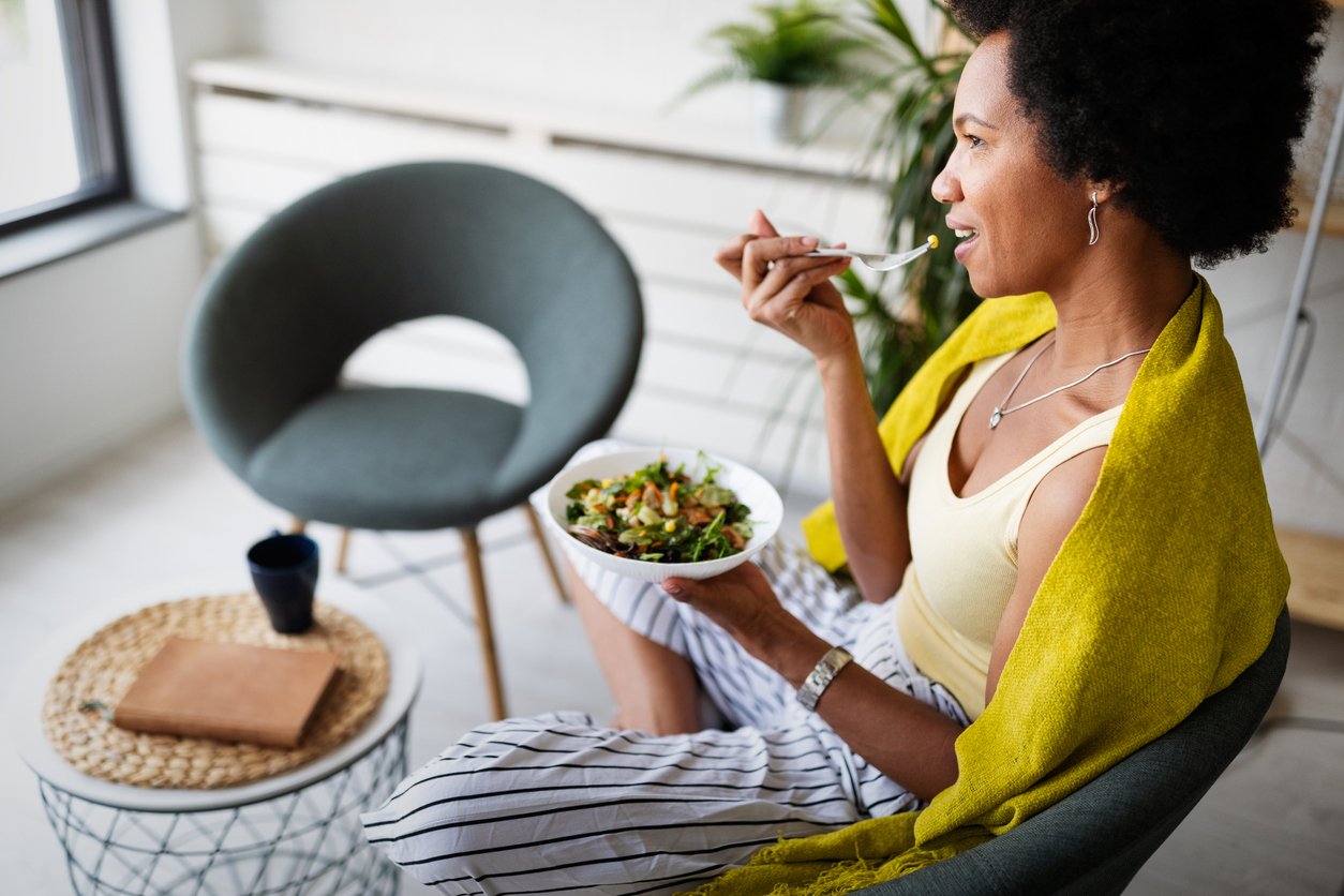 Beautiful black woman eating healthy fresh organic salad