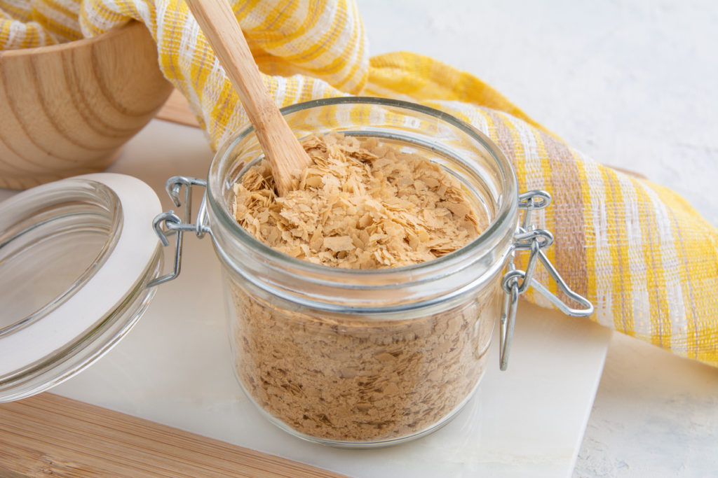 Flakes of Yellow Nutritional Yeast in a glass jar