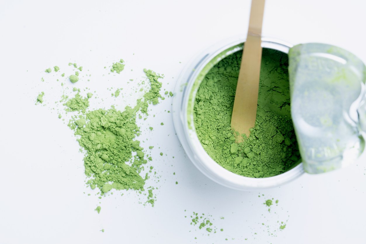 Traditional Japanese matcha tea powder in unsealed can with bamboo scoop Chashaku Isolated. Flat Lay. Top View