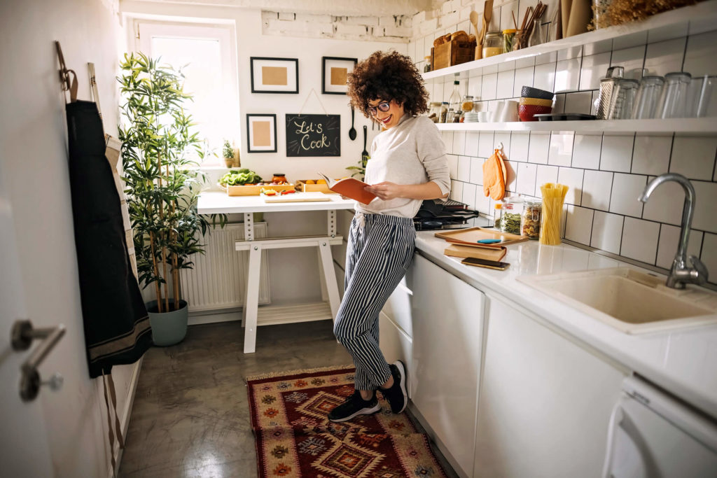 Woman reading a book in her kitchen