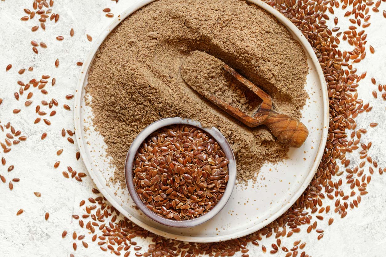 raw flaxseeds in bowl on plate with flax flour